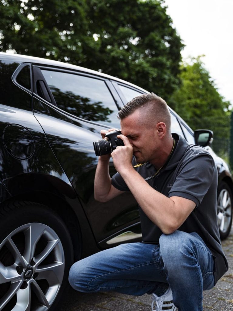 KFZ-Sachverständiger dokumentiert ein Fahrzeug mit der Kamera
